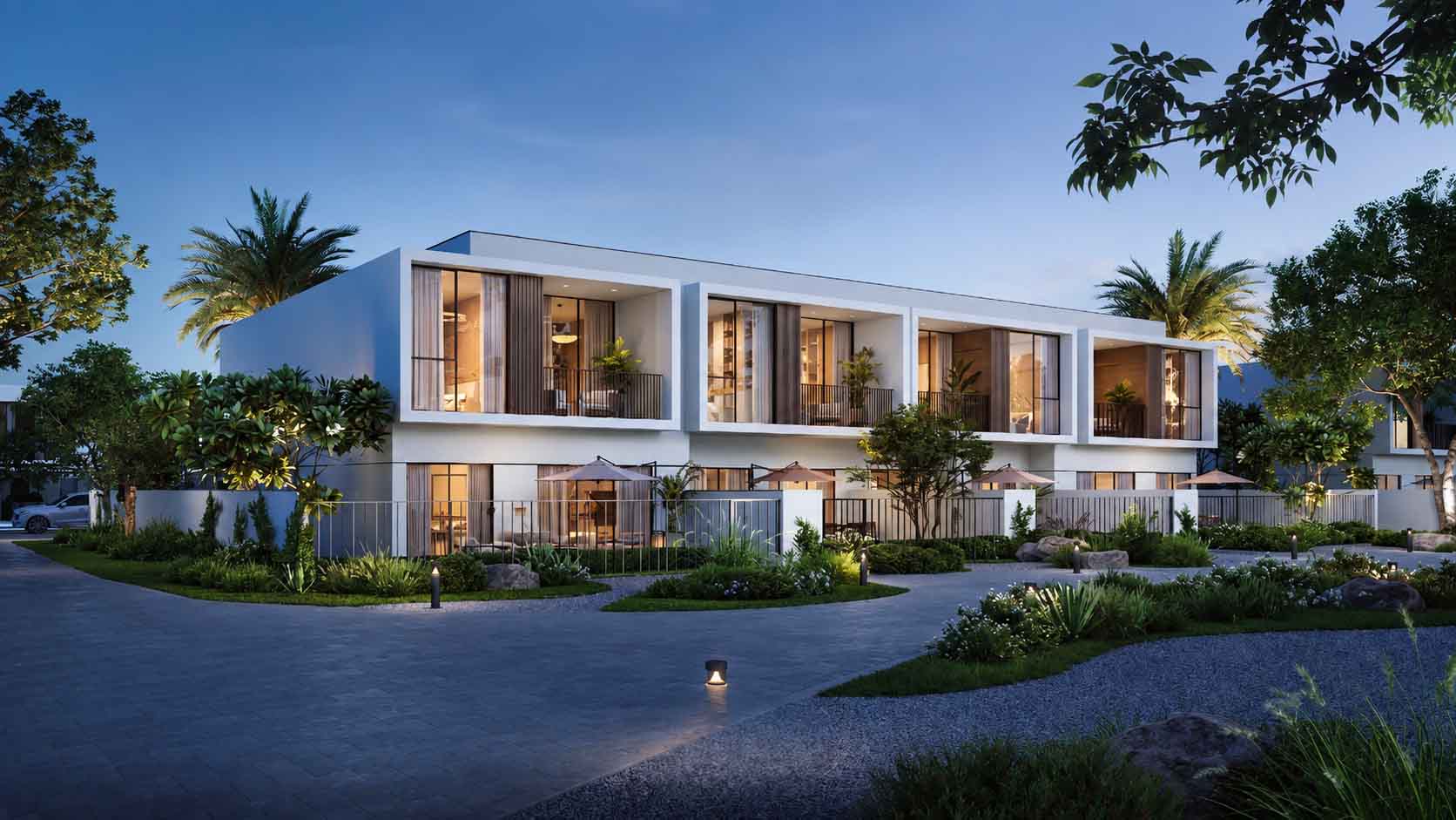 Hileras de casas adosadas en The Valley by Emaar al atardecer, con jardines y un camino de acceso; representación del proyecto Alva